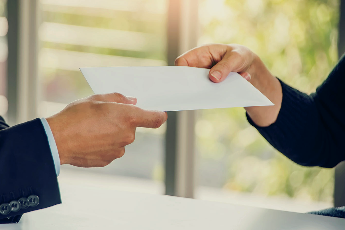An envelope being exchanged in a professional setting